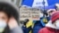 "Наслаждайтесь российским газом с запахом украинской крови" – плакат в руках участницы демонстрации в поддержку Украины в Германии