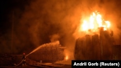 Pompierii încearcă să stingă incendiul provocat de un atac cu rachete asupre unei substații energetice de la Liov, 3 mai 2022.