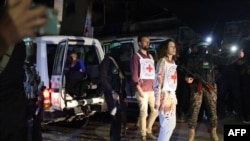 Членове на Червения кръст в очакване да получат израелски заложници от Хамас. Снимката е от 28 ноември
