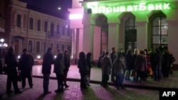 Люди стоять допізна в черзі за грошима біля банківського відділення в Сімферополі, 13 березня 2014 року