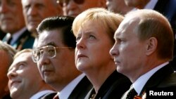 Angela Merkel német kancellár és Vlagyimir Putyin orosz elnök katonai felvonulást néz Moszkvában 2010. május 9-én