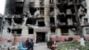 Місцеві жителі зібралися біля зруйнованого житлового будинку в Маріуполі, квітень 2022 року