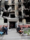 Місцеві жителі зібралися біля зруйнованого житлового будинку в Маріуполі, квітень 2022 року