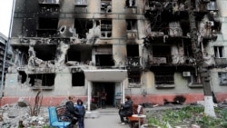 Місцеві жителі зібралися біля зруйнованого житлового будинку в Маріуполі, квітень 2022 року