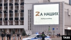 Полицейский в Краснодаре на фоне символов пропаганды войны России против Украины, иллюстративное фото