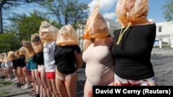 People stand with fake blood on their legs and plastic bags over their heads during an anti-war protest outside the Russian Embassy in Prague in May.