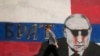 Një grua duke kaluar pranë një murali të presidentit rus, Vladimir Putin. Në muralin që pastaj është lyer me ngjyrë, shkruan "Vëllai". Beograd, 7 maj 2022.
