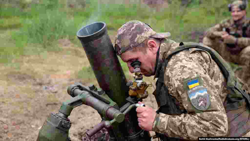 A Ukrainian mortarman lines up his sight on an enemy target.