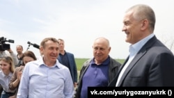 Премьер Крыма Юрий Гоцанюк (слева) и российский глава Крыма Сергей Аксенов (справа) на полях Красноперекопского района, 29 апреля 2022 года
