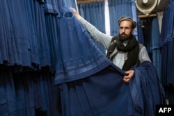 An Afghan vendor displays a burqa at a Kabul market on May 8.