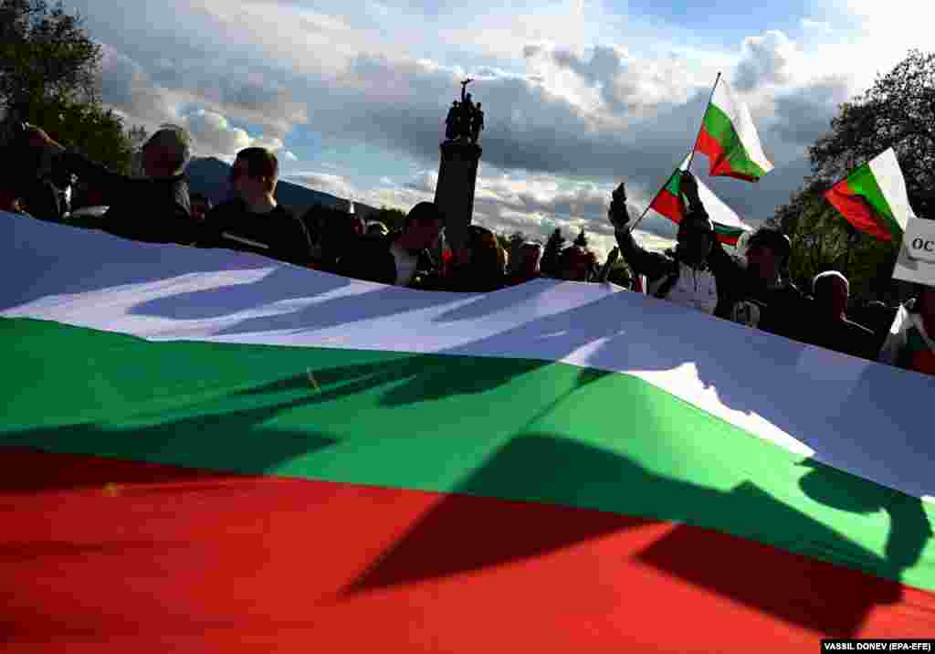 Supporters of Russia wave Bulgarian flags during a protest as supporters of Ukraine also rally on the other side of a monument to the Soviet Army in Sofia.