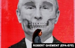 რუმინელი ქალი გვერდზე უვლის ბუქარესტში რუსეთის საელჩოს კედელზე 29 აპრილს ჩამოკიდებულ ვლადიმირ პუტინის ნახატს. სპეციალურ მხატვრულ აქციაზე, სახელწოდებით „ქუჩის ხელოვნების გამოფენა“, წარმოდგენილი იყო უკრაინელი და რუმინელი მხატვრების ნამუშევრები.