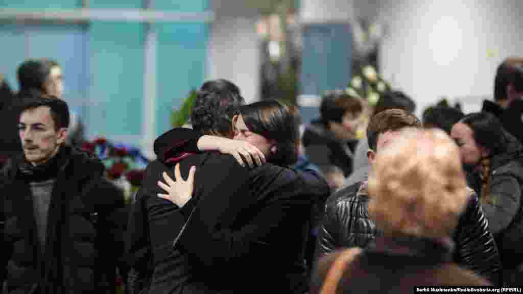 Mourners embrace at the airport.