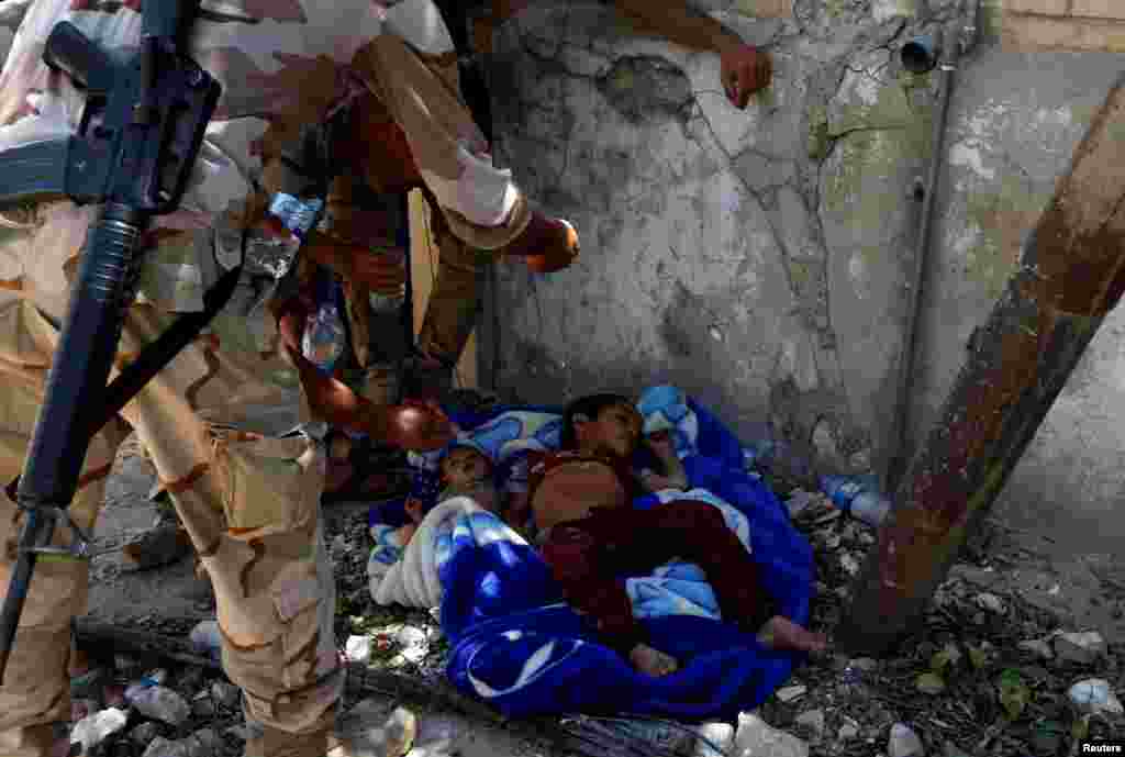 Iraqi soldiers give droplets of water to dehydrated children rescued by soldiers at the site of fighting between Iraqi forces and Islamic State militants near the Old City in western Mosul. (Reuters/Erik De Castro)