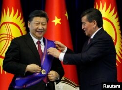 Сооронбай Жээнбеков, будучи президентом Кыргызстана, награждает президента Китая Си Цзиньпина орденом «Манас» во время встречи в Бишкеке. 13 июня 2019 года