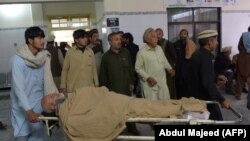 Pakistani men transport an injured bombing victim at a hospital in Kohat on November 23.