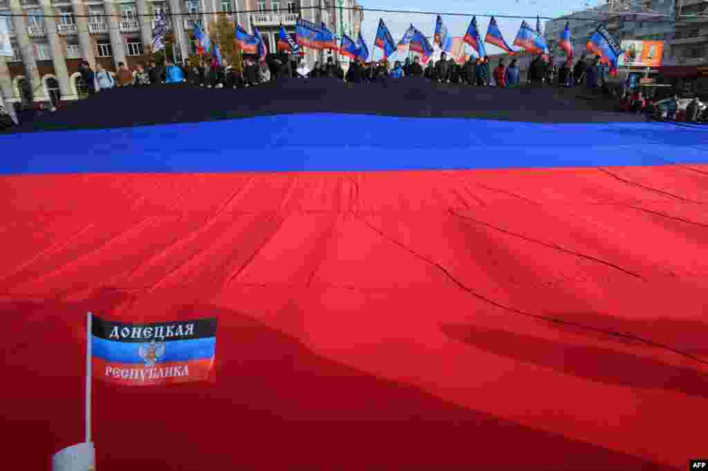 Supporters carry a huge flag of the self-proclaimed Donetsk People&#39;s Republic during a ceremony in&nbsp;Donetsk. (AFP/Dominique Faget)
