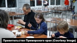 Ukrainian refugees from Mariupol eat a meal at a center for refugees in Primorsky Krai.
