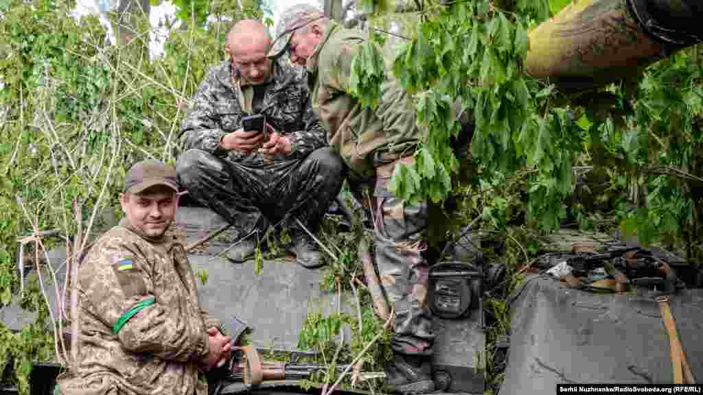 Українські військові на позиціях біля захопленого у російських військ танка Т-80, Харківська область, 1 травня 2022 року