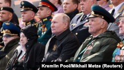 Рускиот претседател Владимир Путин ја гледа воената парада на Денот на победата, со кој се одбележува 77-годишнината од победата над нацистичка Германија во Втората светска војна, на Црвениот плоштад во центарот на Москва, Русија, 9 мај 2022 година.