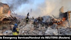 Ekipet e emergjencës shuajnë zjarrin në ndërtesën e shkollës së sulmuar në Luhansk të Ukrainës. Maj, 2022.