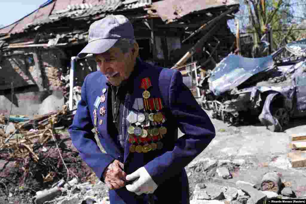 Veteran Drugog svjetskog rata Ivan Lisun (97) nosi jaknu sa svojim ordenima u blizini svoje kuće u Zoločivu, blizu Harkiva, koja je oštećena nakon ruskog napada 6. maja.