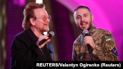 Bono (left) and Taras Topolia, a Ukrainian serviceman and the frontman of the band Antytila, sing during a performance inside a subway station in Kyiv on May 8.