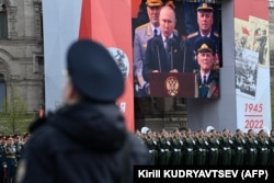 Discurusl președintelui rus Vladimir Putin transmis pe ecran mare în Piața Roșie de la Moscova, 9 mai 2022