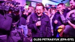 Боно и китаристът на U2 Дейв „Едж“ Евънс изнесоха изненадващ концерт в киевското метро на 8 май 2022 г. 