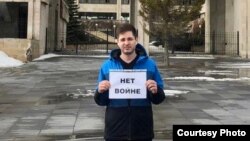 Aleksandr Dneprov protests with a sign saying 'No to war.'
