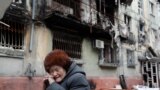 UKRAINE-CRISIS/MARIUPOL/A woman sits on a bench in front of a residential building heavily damaged during Ukraine-Russia conflict in the southern port city of Mariupol, Ukraine April 21, 2022. REUTERS/Alexander Ermochenko