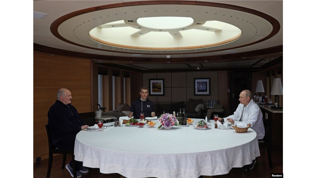 Lukashenka (left) and his son Mikalay (center) dine at sea with Putin aboard the Chaika.