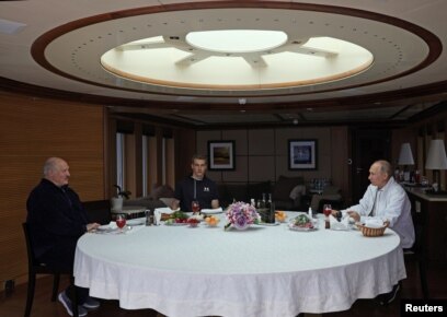 Lukashenka (left) and his son Mikalay (center) dine at sea with Putin aboard the Chaika.