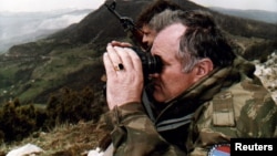 Ratko Mladic monitors a battle against Muslim forces from his shelter on the top of a hill near the Bosnian city of Gorazde in 1994.