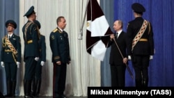 Russian President Vladimir Putin (2nd right) and National Guard chief Viktor Zolotov (3rd left) take part in a ceremony marking National Guard Day in Moscow on March 27.