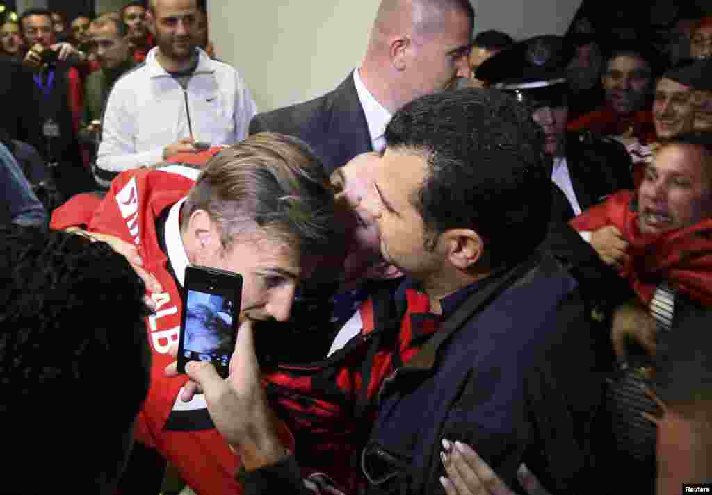 Albanian fans kiss and hug the captain of their national soccer team, Lorik Cana (center), upon his return from a Euro 2016 qualifying match between Serbia and Albania, which was abandoned after a mass brawl between both sets of players. (Reuters)