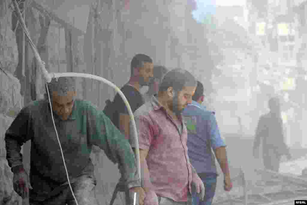 On October 11, dust-covered civilians inspect the rubble of a destroyed building&nbsp;in the Bustan al-Qasr district of Aleppo.&nbsp;Backed by Russian air strikes, Syrian government forces have advanced into rebel-held areas in a bid to recapture the entire city.