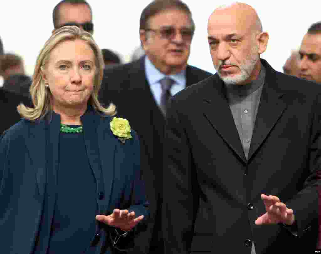 Karzai accompanies U.S. Secretary of State Hillary Rodham Clinton as they arrive for a joint press conference in Kabul on October 20, 2011. 