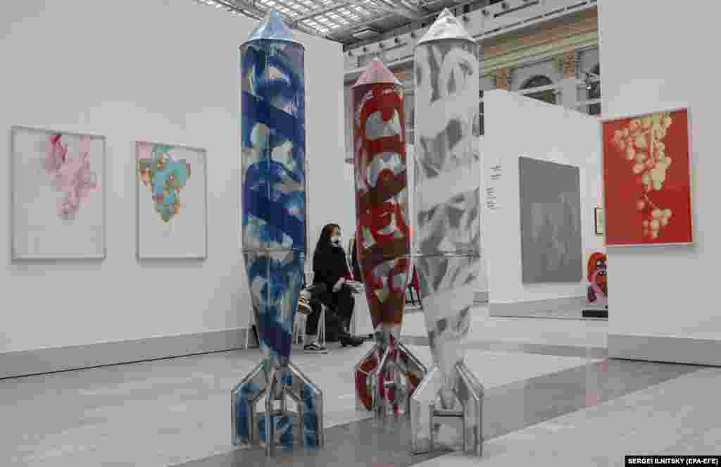 A woman rests near artworks by Stano Filko of Slovakia.