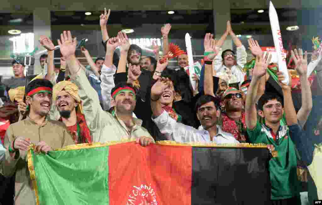 India -- Afghan cricket spectators cheer for their team ahead of the start of the World T20 cricket tournament match between Sri Lanka and Afghanistan at The Eden Gardens Cricket Stadium in Kolkata on March 17, 2016. هند: د کولکتې په اېدن لوبغالي کې د سريلانکا او افغانستان ترمنځ د شل شل اووریزه کرکټ نړیوال جام لوبه کې د افغانستان لوبډلې مېنوال د خوښۍ چیغې وهي. د مارچ په ۱۷مه ۲۰۱۶م کال