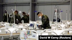 Ushtarë çekë duke bërë gati shtretërit për pacientët me koronavirus. Pragë, tetor 2020. 