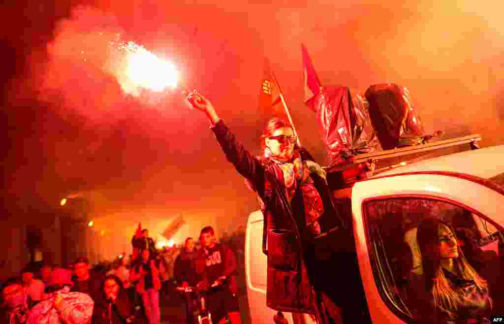 Protestors light flares and wave flags marching through a street during an antigovernment protest in Skopje, Macedonia, on May 16. (AFP/Robert Atanasovski)