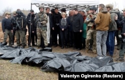 European Commission President Ursula von der Leyen (center) and other European leaders stand next to bodies exhumed from a mass grave in Bucha on April 8.