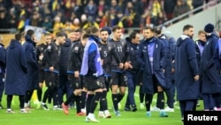 Kosovar players walk off the field in Bucharest on November 15.