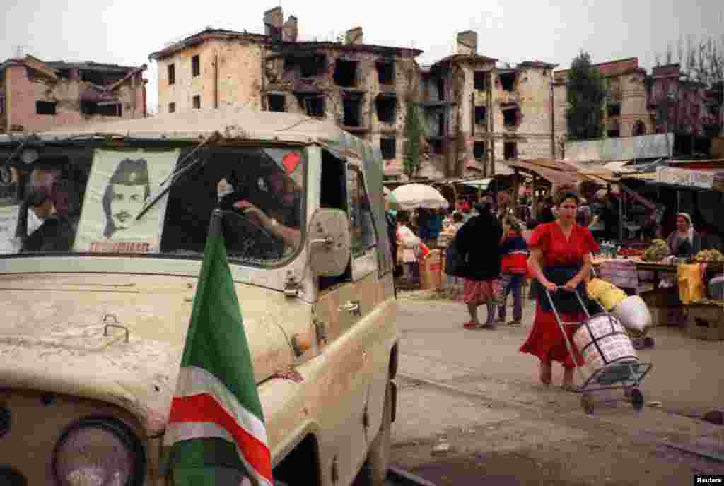 NO - Chechen fighters drive away from the central market place in Grozny - that market place was moved, previously it was located on the end of Mira street