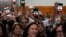 People hold up phones displaying the words "Free Iran" as President Joe Biden addresses a crowd in San Diego on November 3.