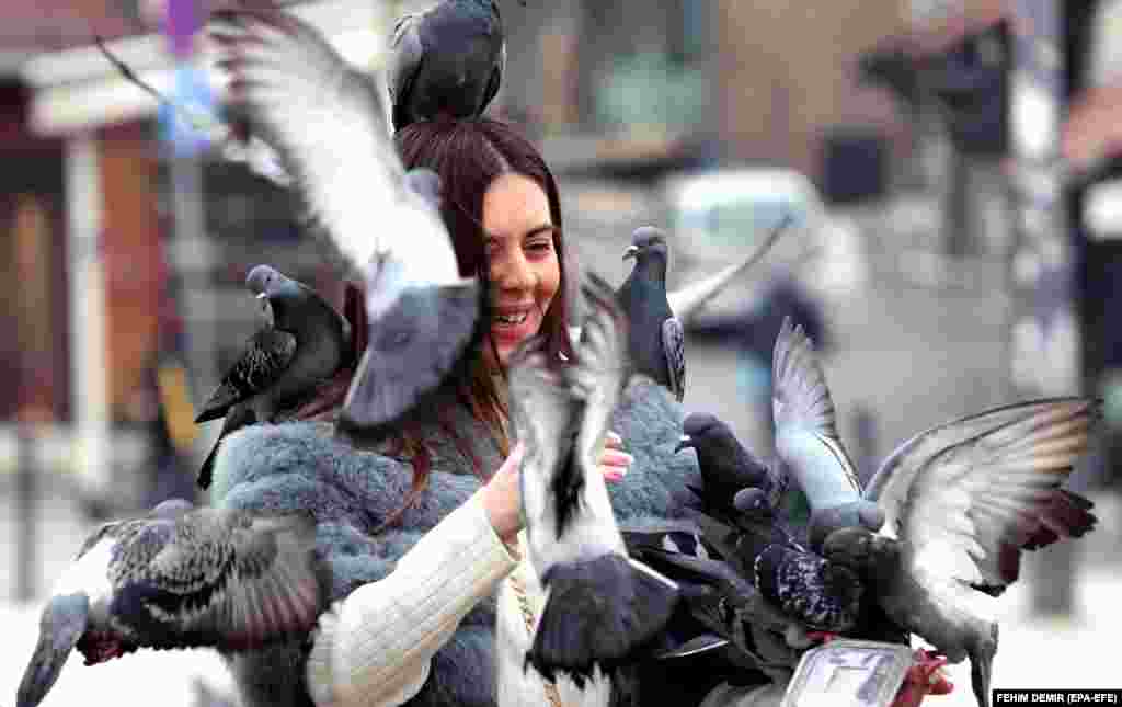 A woman feeds pigeons in the old town of Sarajevo.