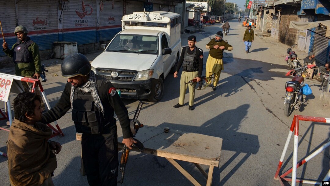 Pakistani police stand guard at a roadblock after Taliban militants seized a police station in Bannu, Khyber Pakhtunkhwa Province, on December 19.