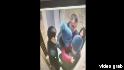 Полицияның белсенді Достияровты кішкентай қызымен бірге ұстап әкетпек болған сәті. Бақылау камерасынан алынған видеодан скриншот.