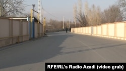 A wide, paved road with barriers on both sides in Araliq.